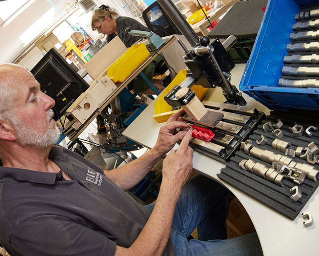 Mitarbeiter pr�ft an seinem Montageplatz die Qualit�t eines Werkst�ckes