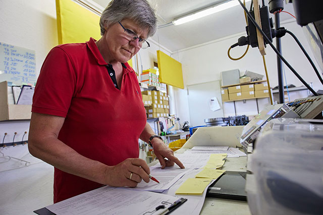 Eine Mitarbeiterin pr�ft an ihrem Arbeitsplatz St�cklisten