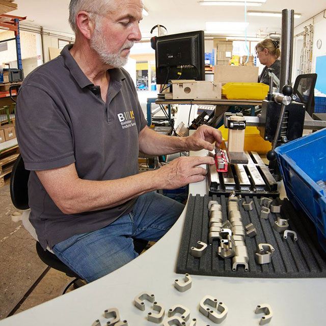 Ein Mitarbeiter montiert und sortiert Kleinteile